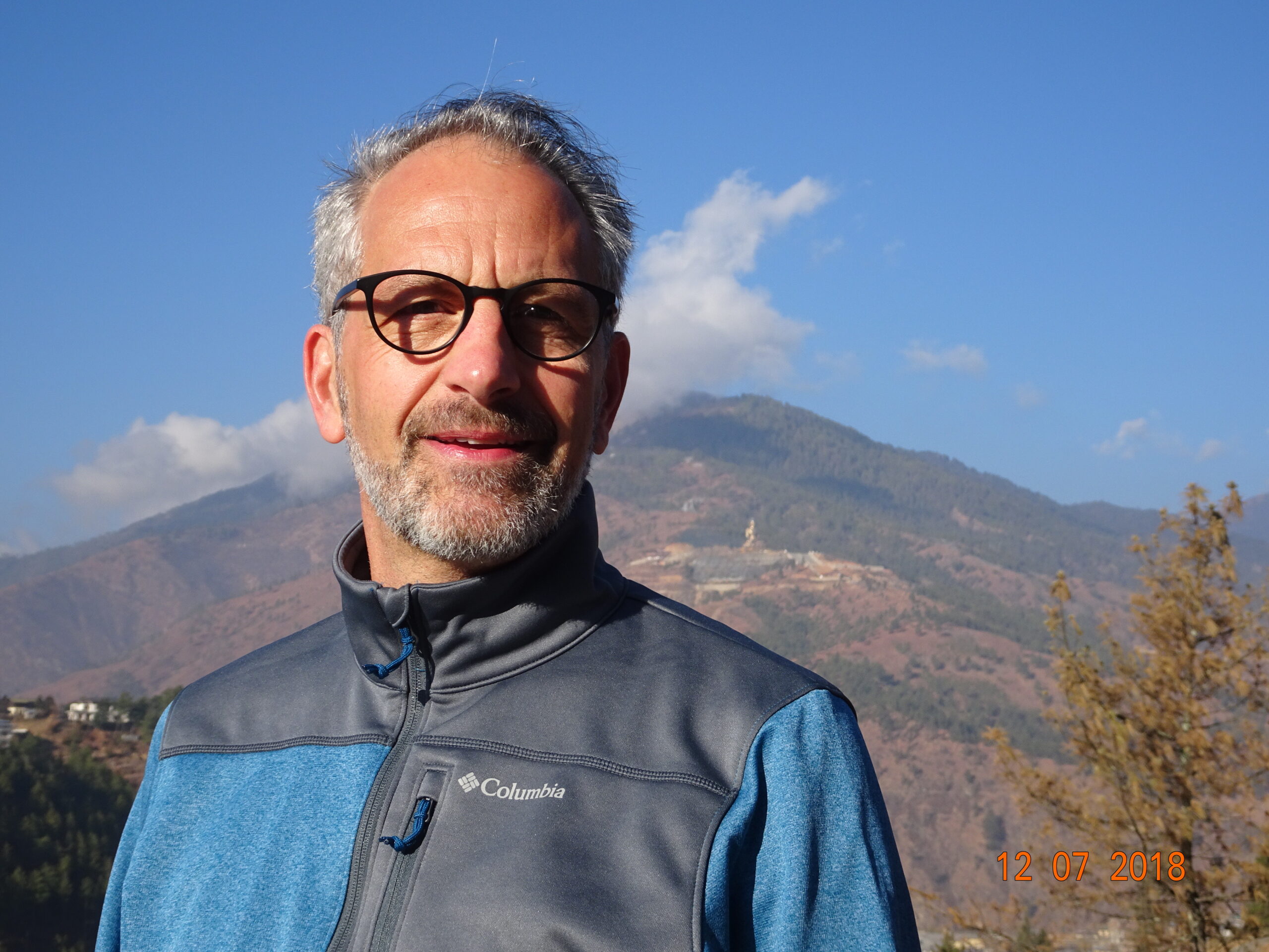 James standing in front of a mountain range in Bhutan.